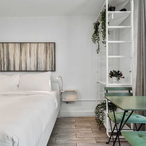 A sunlit workspace right by the window with refreshing green accents. The ultimate setup for a productive remote work morning or breakfast for two.