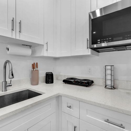The kitchenette fully stocked with silverware, plates, and essential cookware, making it easy to prepare and enjoy meals during your stay.