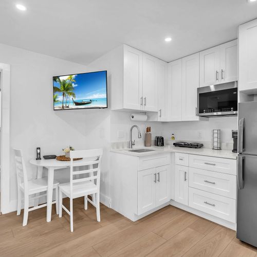 Clean and practical kitchenette featuring a fridge, electric cooktop, microwave, Keurig, and ample storage for your stay.