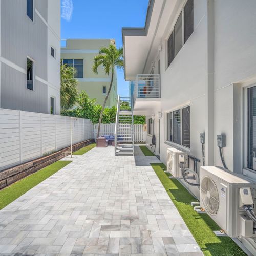 Enjoy a large open outdoor space with a backyard lounge area surrounded by tropical greenery.