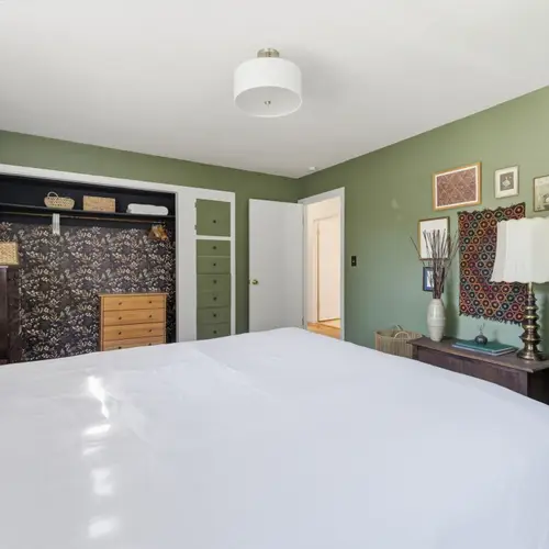 Bright and inviting queen bedroom with cozy touches throughout.