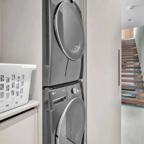 Enjoy the ultimate convenience of an in-unit laundry area during your stay. Tucked away seamlessly behind a sliding door, this space features a premium stacked front-load washer and dryer.