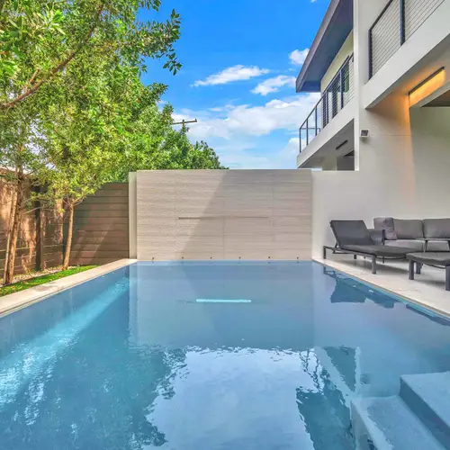 Escape to your own private paradise. This spectacular backyard oasis features a pristine, crystal-clear swimming pool surrounded by a sleek sun deck and comfortable lounge chairs.
