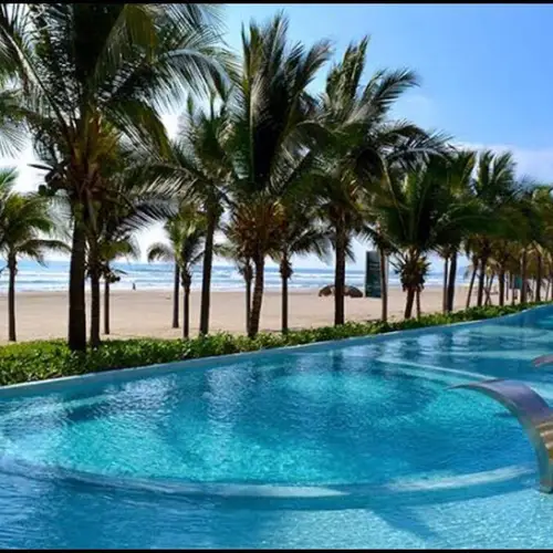 Palm-lined pool steps from the beach