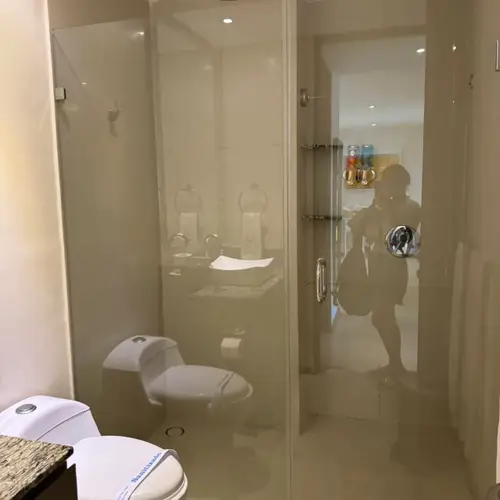 Walk-in glass shower with rain showerhead and fresh towels