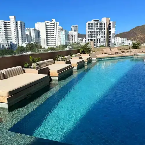 Lap pool with built-in sun loungers and city views