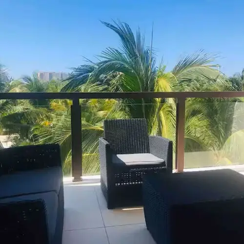 Balcony with outdoor seating among the palms