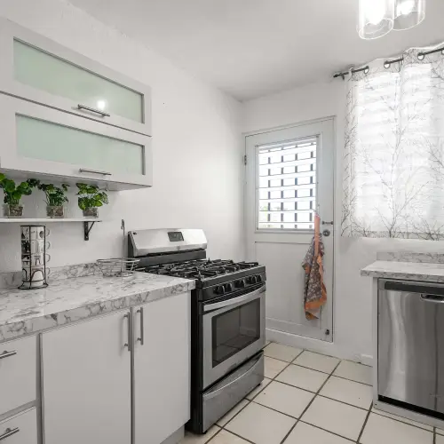 Kitchen with white cabinets, gas stove and dishwasher