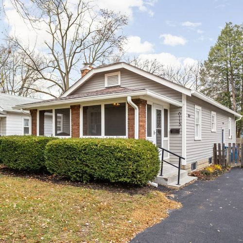 Charming Exterior: Enjoy peaceful moments on the shaded front porch surrounded by vibrant greenery!