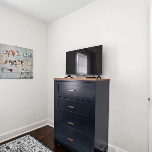 Bedroom: Relax in style with a sleek dresser, TV, and charming bird artwork!