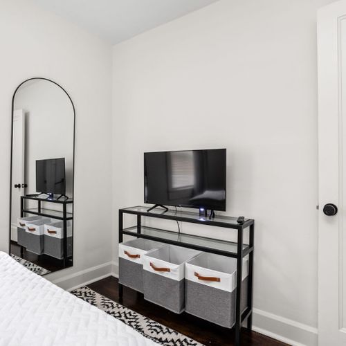 Bedroom: Stylish space with a sleek TV, chic mirror, and modern storage solutions!