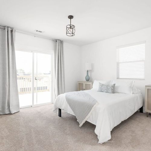 Primary Bedroom: Bright and airy space with modern decor, queen bed, and private balcony access!