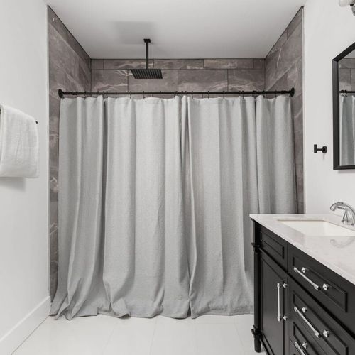 Primary Bathroom: Modern elegance meets functionality with sleek black cabinetry and spacious shower.