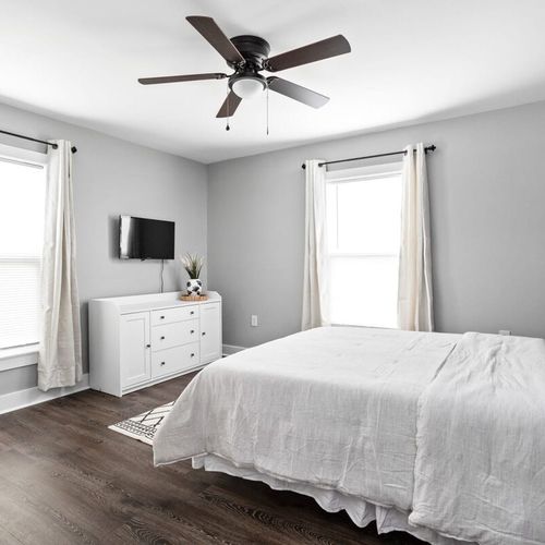 Cozy up in bedroom featuring a queen bed, closet, TV and a stylish accent wall.