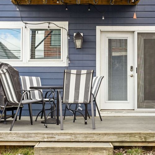 Our back porch features a dining table set for four, creating the perfect spot for outdoor meals and gatherings.
