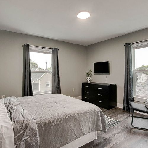 Relax in the main bedroom with a functional dresser, closet, tv and additional seating for your comfort.