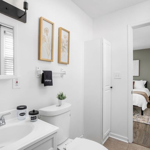 An elegantly decorated bathroom equipped with all the essential elements you need, including fresh towels, shampoo, conditioner, and body wash.