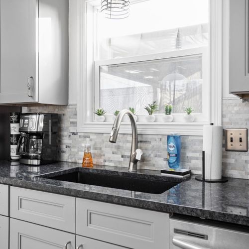 Kitchen: Bright and modern space with sleek granite counters and stylish light fixtures!