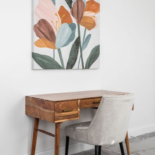 Workspace: Enjoy a stylish desk and chic chair with vibrant floral art for inspiration!