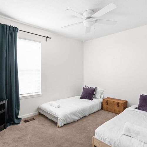 Experience the comfort of both a cozy single beds, adorned with fresh linens and soft pillows. The room features a window for natural light and a bookshelf for your reading pleasure.