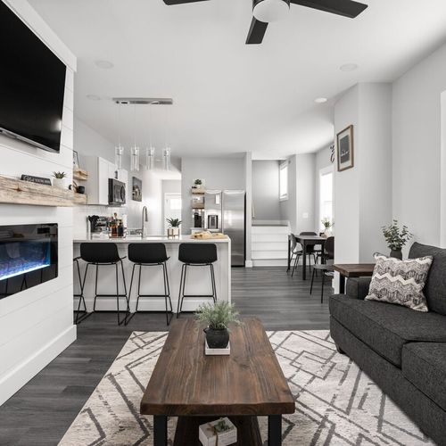 Living Room: Bright and stylish space with sleek furniture, a flickering fireplace, and vibrant decor!