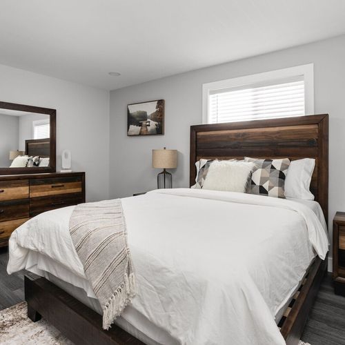 Bedroom: Stylish room with a plush queen bed, sleek wooden furniture, and inviting natural light!