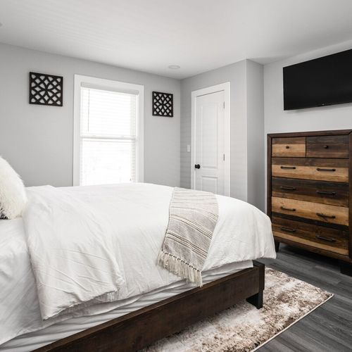 Bedroom: Stylish room with a plush queen bed, sleek wooden furniture, and inviting natural light!