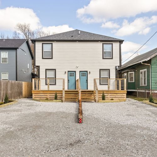 Exterior: Experience modern charm with vibrant blue doors, spacious deck, and quaint garden vibes! Please note this is a duplex and parking is designated to one side! Parking for up to 2 cars!