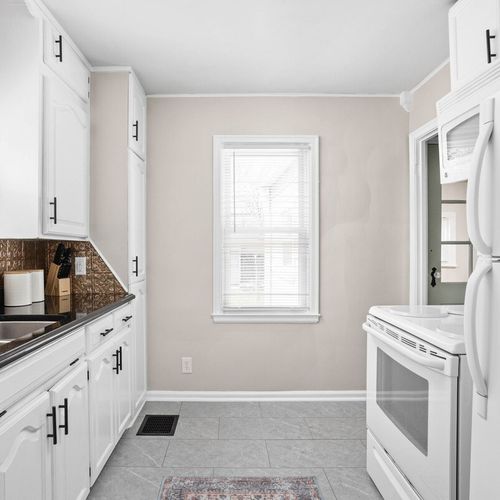 Experience the striking elegance of our kitchen, gleaming with cleanliness and equipped with modern appliances, cooking essentials, and utensils."