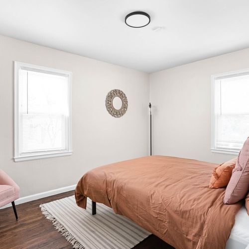Enjoy the coziness of our comfortable bed adorned with fresh linens and sheets, plush pillows, and additional seating near the window for a serene and inviting atmosphere.