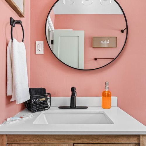 Step into a beautifully designed space featuring a sleek mirror, plush towels, luxurious hand soap, and an elegant sink that adds a touch of sophistication to your daily routine.