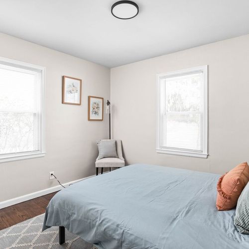 Enjoy the coziness of our comfortable bed adorned with fresh linens and sheets, plush pillows, and additional seating near the window for a serene and inviting atmosphere.