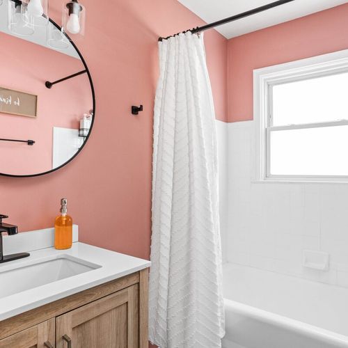 Step into a beautifully designed space featuring a sleek mirror, plush towels, luxurious hand soap, and an elegant sink that adds a touch of sophistication to your daily routine.