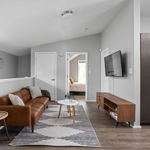 Unwind in this cozy area featuring a soft sofa, coffee table, and TV, creating the perfect space for relaxation and entertainment.