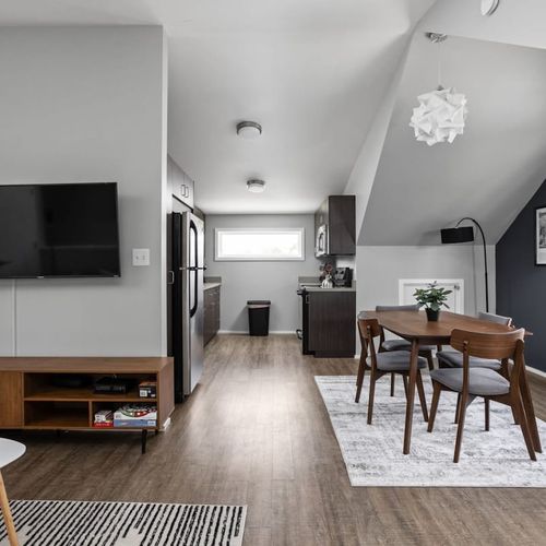 On one side, you'll find a TV, and on the right side, a four-seating dining table for your convenience.