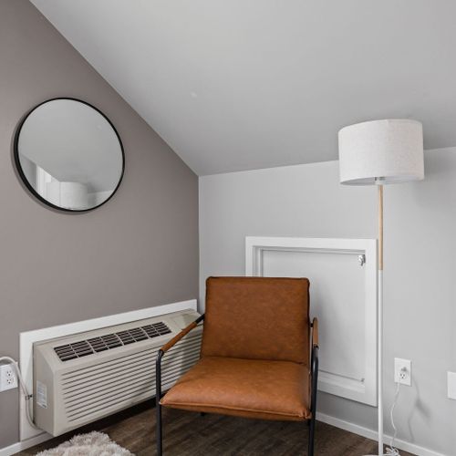 Enhance the ambiance with a lamp, additional seating, and the comfort of air conditioning, complemented by decorative mirrors for added style.