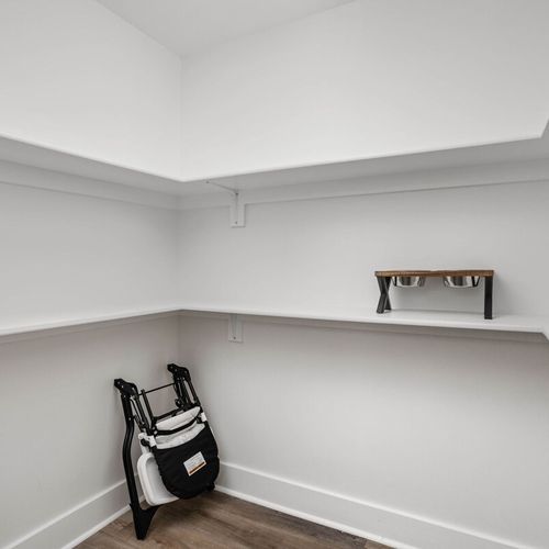 Ample closet space, with a highchair, broom, and dog bowls!