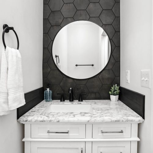 Our well-appointed bathroom featuring an elegant mirror, sink, vanity cabinet, and fresh towels. Complimentary soap is also provided for your convenience and comfort.