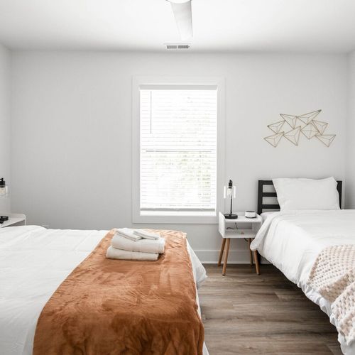 Enjoy the coziness of both a double and a single bed, complete with a bedside table and lamp. Entertainment is at your fingertips with a TV, and the room is illuminated by a window for a delightful stay.