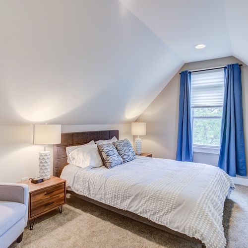 Cozy atmosphere of our bedroom, designed for delightful nights of good sleep. Fresh linens, snug pillows, a bedside table with a lamp, and additional seating create a haven that ensures comfort and tranquility.