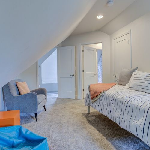 Enjoy our bedroom featuring one cozy double bed and one single bed, adorned with fresh towels, soft pillows, and freshly laundered linens. Complete with a bedside table, lamp, and additional seating near the window, it's a perfect retreat for your comfort.