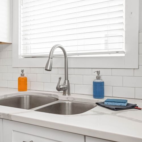 Kitchen features a convenient sink area stocked with hand soaps, sponges, and a few towels, making it easy for you to maintain a clean and tidy space during your stay.
