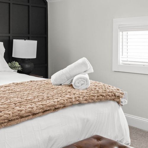 Complete your bedroom experience with a stylish bench and fresh towels for added comfort and convenience.