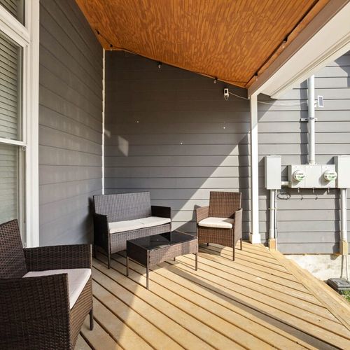 Relax on the backyard porch, complete with comfortable chairs—a perfect spot to unwind and take in the surroundings.