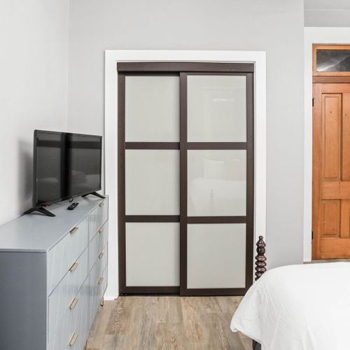 TV for entertainment, a dresser for storage, and a convenient slide door leading to the bathroom for added privacy and accessibility.