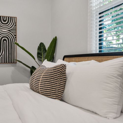 Soft pillows & a woven headboard set the scene for slow, lazy mornings
