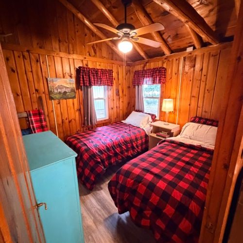 BEDROOM #3:  Features two single beds, a nightstand with a lamp, ceiling fan, and a dresser.