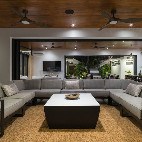 U-shaped sectional in the great room of Casa Oso with retractable glass walls open to the courtyard staircase, Tamarindo, Costa Rica.