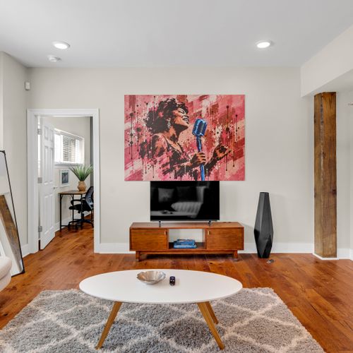 Jazz-inspired art above a warm wood media console