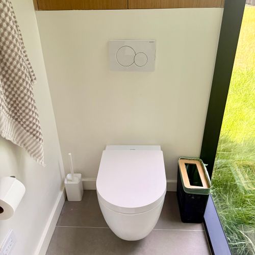 Private water closet with a sculptural stone pedestal vanity.